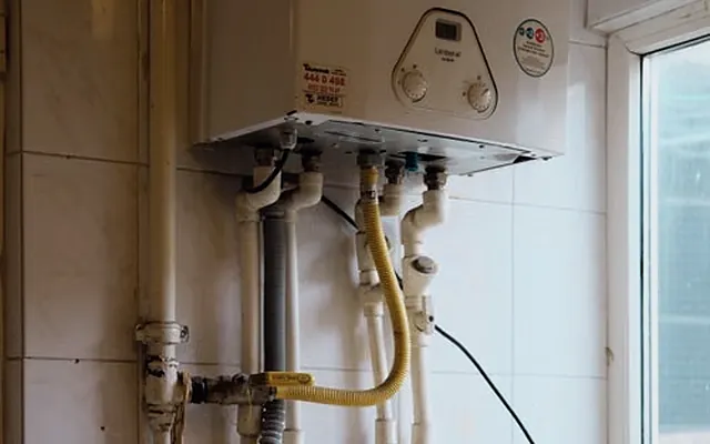 Calentador de agua instalado en muro con conexiones